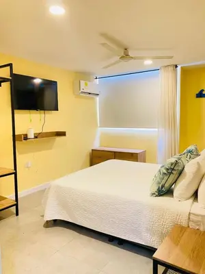 a bedroom with a bed and a flat screen tv at Laguito Houstel Small in Cartagena de Indias
