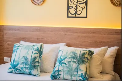 a bed with two blue and white pillows on it at Laguito Houstel Small in Cartagena de Indias