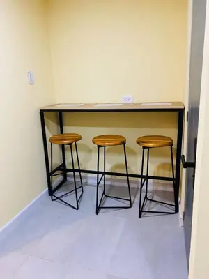a desk with two stools in a room at Laguito Houstel Small in Cartagena de Indias