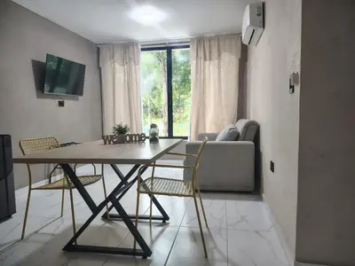a dining room table with chairs and a couch at Laureles del parque loft in Barranquilla