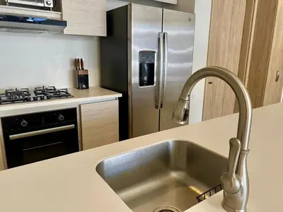 a kitchen with a sink and a stainless steel refrigerator at Hermoso Apartamento Cartagena Salida directa al Mar in Cartagena de Indias
