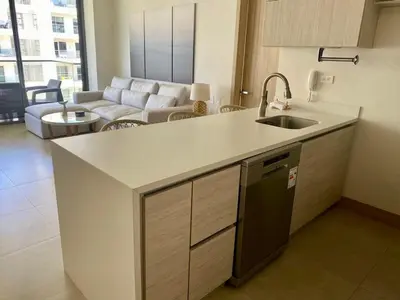 a kitchen with a sink and a living room at Hermoso Apartamento Cartagena Salida directa al Mar in Cartagena de Indias