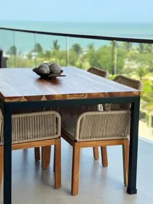 a wooden table with chairs and a table with a shell on it at Hermoso Apartamento Cartagena Salida directa al Mar in Cartagena de Indias