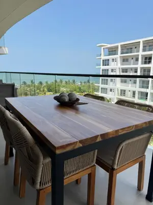 a wooden table and chairs with a view of a building at Hermoso Apartamento Cartagena Salida directa al Mar in Cartagena de Indias