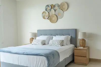 a bedroom with a large bed with hats on the wall at Hermoso Apartamento Cartagena Salida directa al Mar in Cartagena de Indias