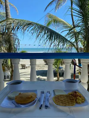 a table with a plate of food on the beach at Cabañas Kosta Azul in San Bernardo del Viento