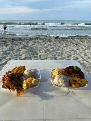 two plates of food on a table on the beach at Cabañas Kosta Azul in San Bernardo del Viento