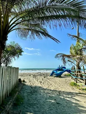 a blue motorcycle parked on a beach near the ocean at Cabañas Kosta Azul in San Bernardo del Viento