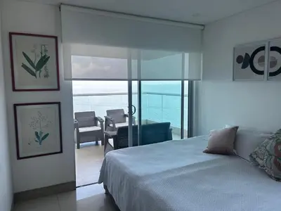 a bedroom with a bed and a view of the ocean at HERMOSO APARTAMENTO VISTA AL MAR PALMETTO SUNSET-El Laguito in Cartagena de Indias
