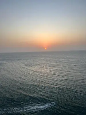 a sunset over the ocean with a boat in the water at HERMOSO APARTAMENTO VISTA AL MAR PALMETTO SUNSET-El Laguito in Cartagena de Indias
