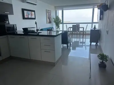 a kitchen with a counter and a dining room at HERMOSO APARTAMENTO VISTA AL MAR PALMETTO SUNSET-El Laguito in Cartagena de Indias