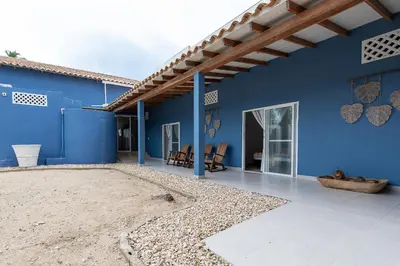 a blue building with chairs and a patio at Cabaña Tio Chin in Coveñas