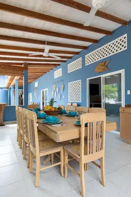a dining room with a wooden table and chairs at Cabaña Tio Chin in Coveñas