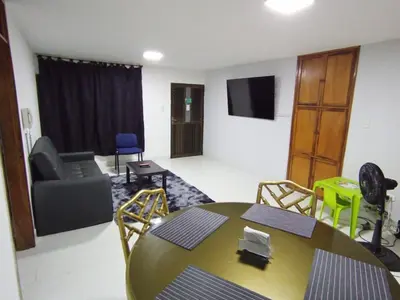 a living room with a table and a chair at Apartamento para carnavales in Barranquilla