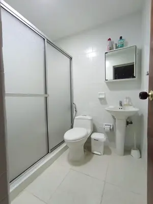 a white bathroom with a toilet and a sink at Apartamento para carnavales in Barranquilla