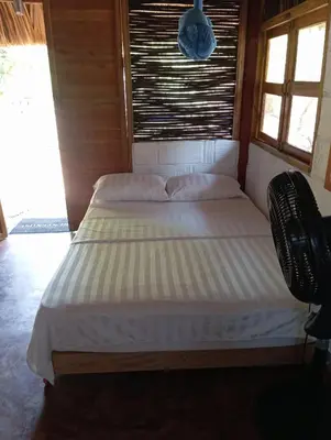 a bed in a room with two pillows on it at Hospedaje VILLA CRETA in Isla Fuerte