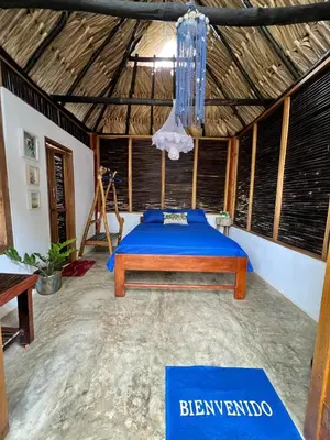 a bedroom with a bed in a room with a wooden ceiling at Hospedaje VILLA CRETA in Isla Fuerte