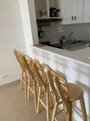 a row of wooden chairs sitting next to a kitchen counter at Duplex playa y mar in Cartagena de Indias