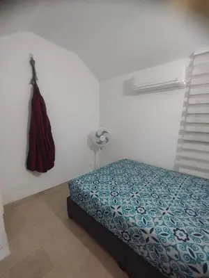 a bedroom with a bed and a dress hanging on a wall at Duplex playa y mar in Cartagena de Indias