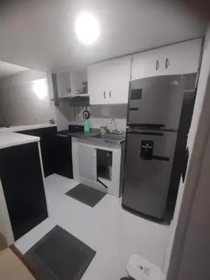 a kitchen with white cabinets and a stainless steel refrigerator at Duplex playa y mar in Cartagena de Indias