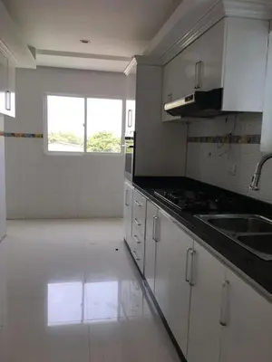 a kitchen with white cabinets and a sink and a window at Valmar apartamentos in Cartagena de Indias