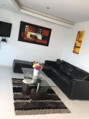 a living room with a black couch and a glass table at Valmar apartamentos in Cartagena de Indias