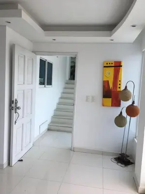 a white hallway with a staircase and a painting on the wall at Valmar apartamentos in Cartagena de Indias
