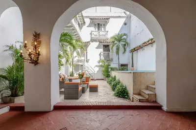 an archway leading to a courtyard with palm trees at Bololá Hotel in Cartagena de Indias