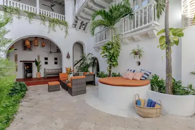 an outdoor patio with a table and chairs and palm trees at Bololá Hotel in Cartagena de Indias