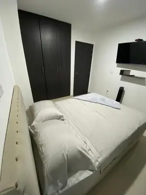 a bedroom with a bed with a tv on the wall at Modern Duplex en Riomar BQuilla in Barranquilla