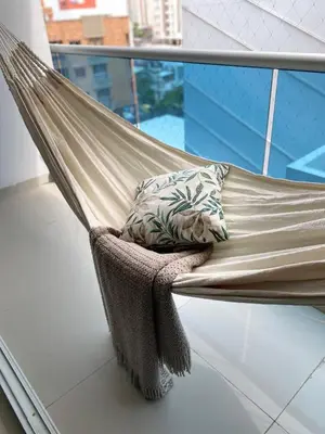 a hammock on a balcony with a pillow at Modern Duplex en Riomar BQuilla in Barranquilla
