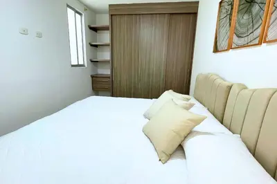 a bedroom with a white bed with a pillow at Apartmento En Miramar in Barranquilla