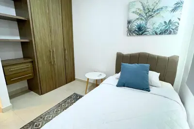 a bedroom with a bed with a blue pillow at Apartmento En Miramar in Barranquilla