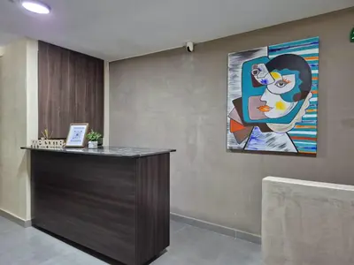 an office with a reception desk with a painting on the wall at Laureles del parque Loft in Barranquilla