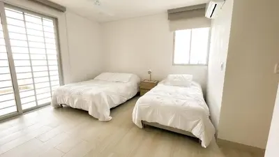 two beds in a room with white walls and windows at Magico Apartamento Frente al Mar 3 Habitaciones TV52 in Coveñas