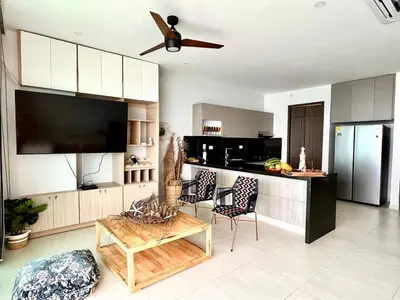 a living room with a kitchen with a flat screen tv at Lovely apartment in front the beach in Coveñas
