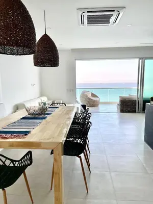 a dining room with a table and chairs and the ocean at Lovely apartment in front the beach in Coveñas