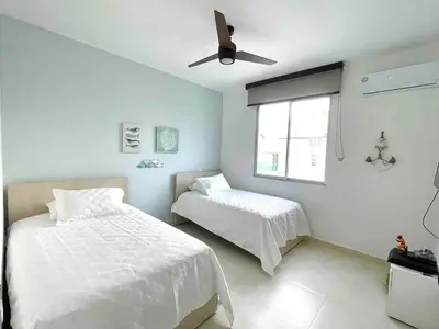 a bedroom with two beds and a ceiling fan at Lovely apartment in front the beach in Coveñas
