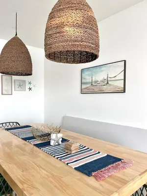 a dining room table with two large wicker chandeliers at Lovely apartment in front the beach in Coveñas