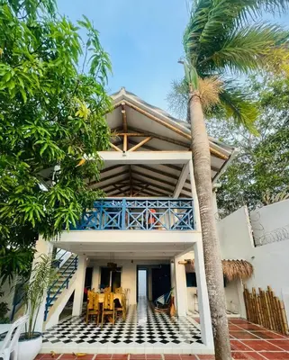 a house with a palm tree in front of it at Cuatro Palmas Beach House in Cartagena de Indias