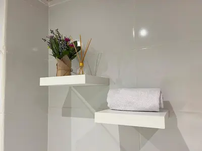 a white room with two white shelves and flowers at Beautiful Studio close to the beach in Cartagena de Indias