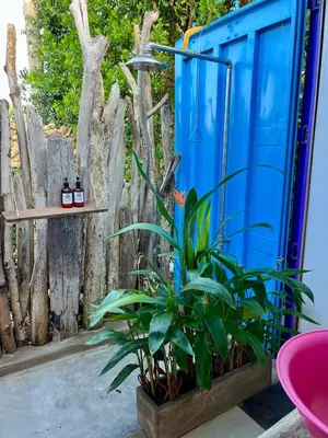 a blue shed with a plant next to a fence at WIND en Mojarra Beach Aire acondicionado Habitación privada in Salina de Rey