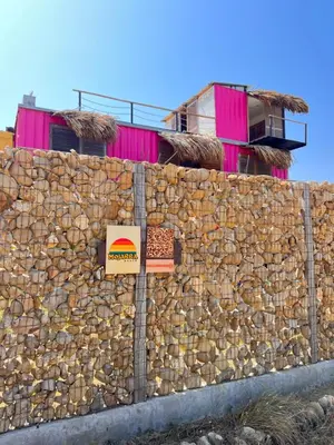 a stone wall with a building behind it at WIND en Mojarra Beach Aire acondicionado Habitación privada in Salina de Rey