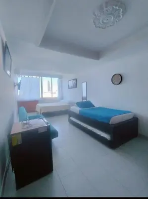 a bedroom with two beds and a table in it at Cartagena in Cartagena de Indias