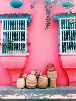 a pink wall with baskets in front of a building at Casa Beatriz Luxury Colonial House in Cartagena de Indias
