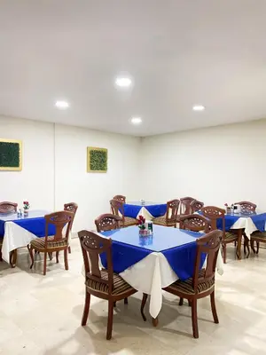 a dining room with blue tables and wooden chairs at Hotel Continental Plaza Barranquilla in Barranquilla