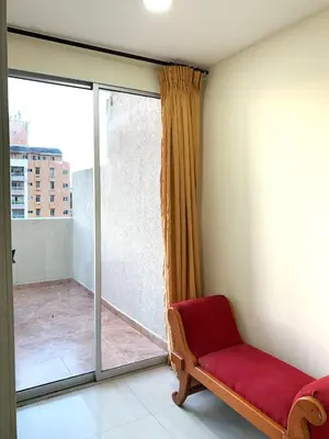 a room with a red couch and a sliding glass door at Hotel Continental Plaza Barranquilla in Barranquilla