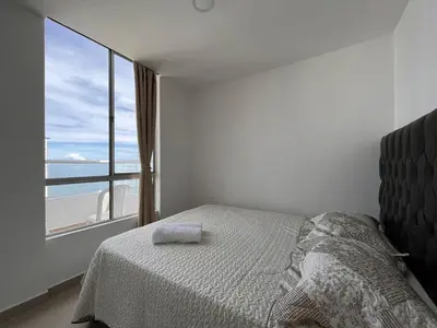 a bedroom with a bed and a large window at Apartamento Aqua in Cartagena de Indias