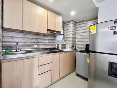 a kitchen with wooden cabinets and a stainless steel refrigerator at Apartamento Aqua in Cartagena de Indias