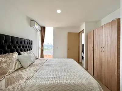 a bedroom with a large bed with a black headboard at Apartamento Aqua in Cartagena de Indias